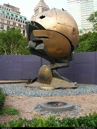 New York : Une flamme pour se souvenir. Ce globe se trouvait entre les 2 tours du World Trade Center et porte les traces de la trgdie. Poignant... 