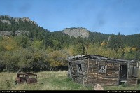 Not in a city : Legacy of the past, in front of the Crazy Horse Monument. This cabin badly needs a new roof, and that great car should receive a new coat of fresh paint!
